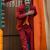 Joker samlerfigur i rødt jakkesæt foran gardiner