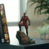 Daredevil statue på hylde ved siden af bøger