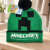 Grøn Minecraft hue med Creeper og sort kvast på en træbænk